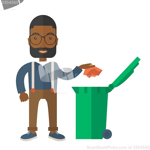 Image of Black man throwing paper in a garbage bin.
