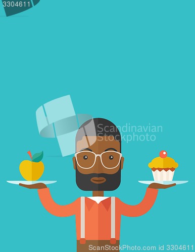 Image of Man carries with his two hands cupcake and apple.