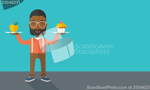 Image of Man carries with his two hands cupcake and apple.