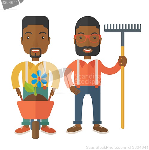 Image of Two black men with wheelbarrow and rake.