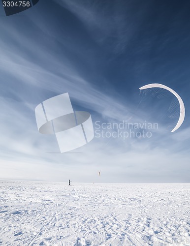 Image of Kiteboarder with blue kite on the snow