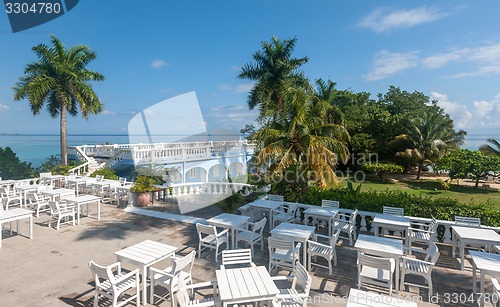 Image of White tables and chairs  in tropical garden  on a beautiful  beach