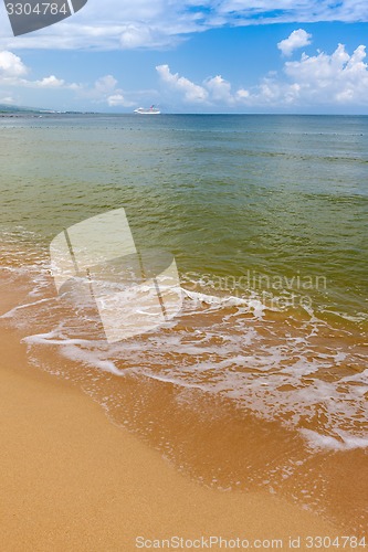 Image of Beach on tropical island. Clear blue water, sand, clouds. 