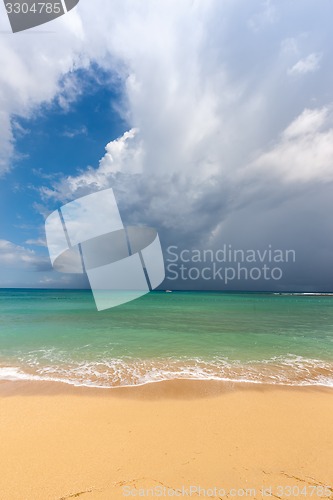 Image of Beach on tropical island. Clear blue water, sand, clouds. 