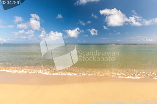 Image of Beach on tropical island. Clear blue water, sand, clouds. 