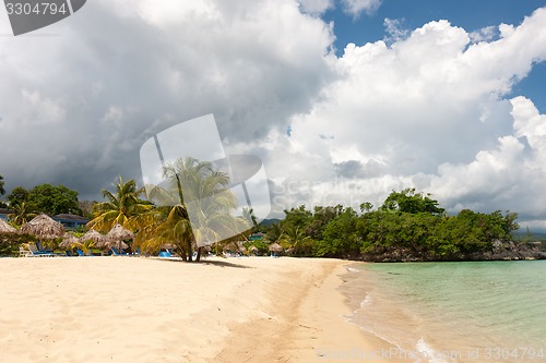 Image of Beach on tropical island. Clear blue water, sand, clouds. 