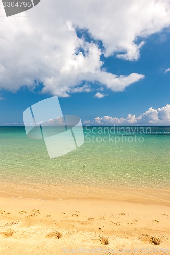 Image of Beach on tropical island. Clear blue water, sand, clouds. 