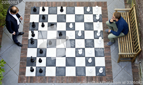 Image of Two men playing a game of outdoor chess