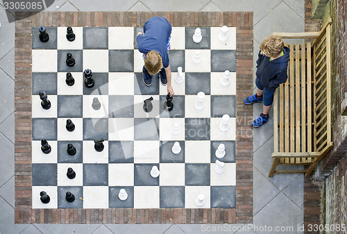 Image of Two boys playing outdoor chess