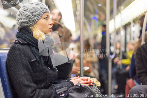 Image of Woman traveling by subway full of people.