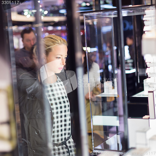 Image of Beautiful woman standing in front of showcase.