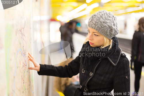 Image of Lady looking on public transport map panel.