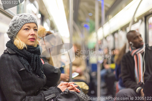 Image of Woman traveling by subway full of people.