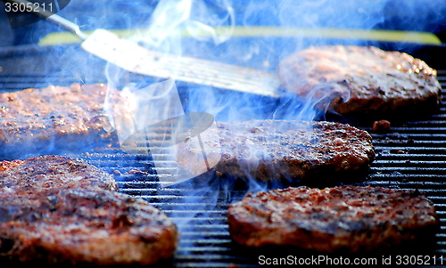 Image of Hamburgers grilling.