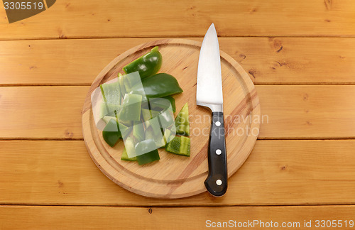 Image of Green pepper being cut with a knife on a chopping board