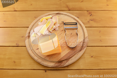 Image of Butternut squash with a vegetable peeler on a chopping board