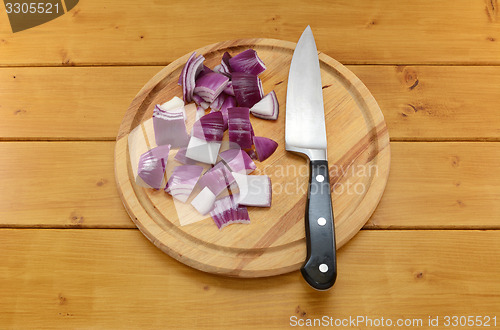 Image of Chopped red onion with a knife on a chopping board