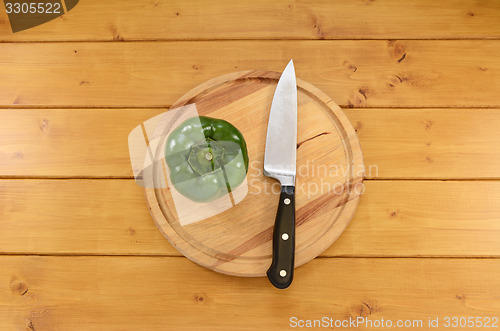 Image of Green pepper with a knife on a cutting board