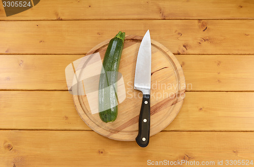 Image of Green courgette with a knife on a chopping board