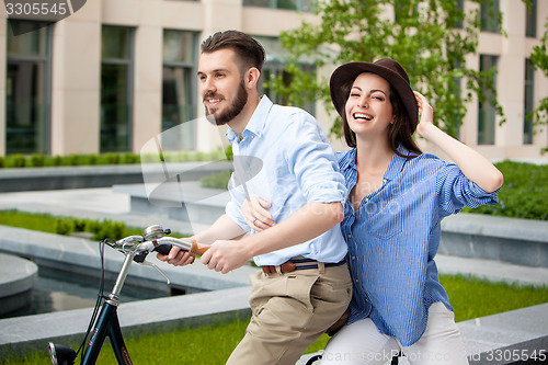 Image of Young couple sitting on a bicycle 