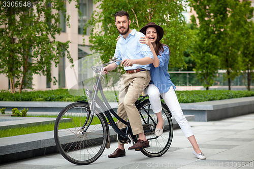 Image of Young couple sitting on a bicycle 