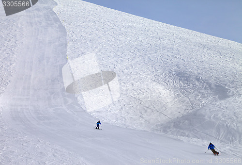 Image of Ski slope and skiers at sun day