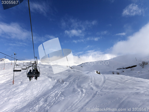 Image of Chair-lift and off-piste slope in wind day