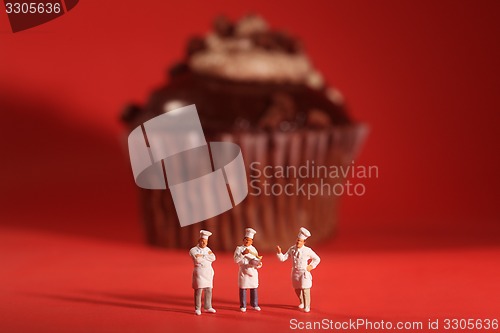 Image of Interesting Rendition of Miniature Chefs With Cupcake