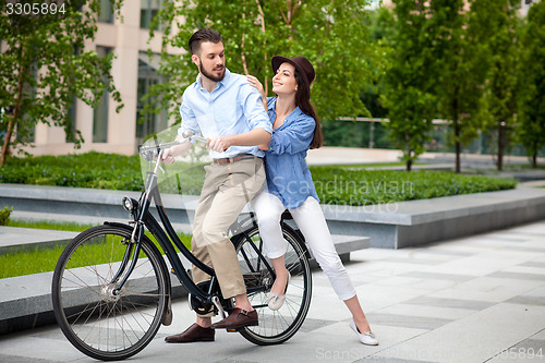 Image of Young couple sitting on a bicycle 