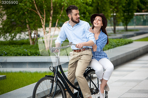 Image of Young couple sitting on a bicycle 