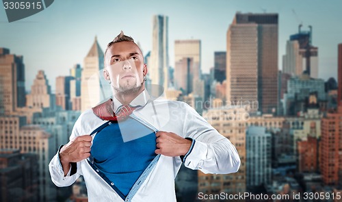 Image of businessman acting like  super hero and tearing his shirt off