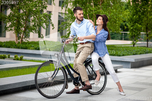 Image of Young couple sitting on a bicycle 