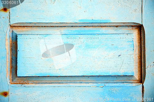 Image of dirty stripped paint in    wood door and rusty nail