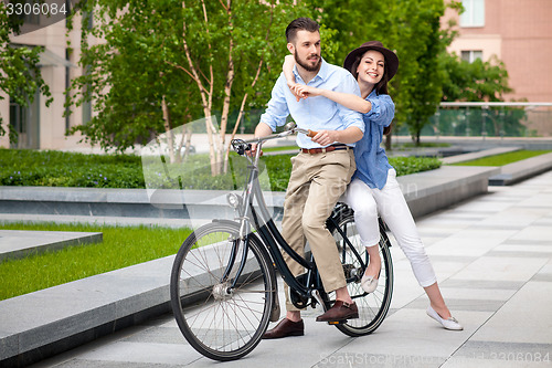 Image of Young couple sitting on a bicycle 