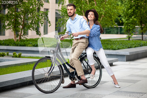 Image of Young couple sitting on a bicycle 
