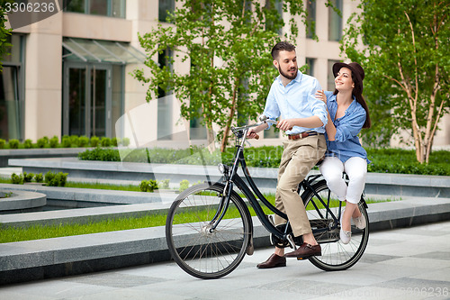 Image of Young couple sitting on a bicycle 