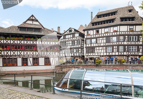 Image of STRASBOURG, FRANCE - SEPTEMBER 26 2008: Strasbourg, water canal in Petite France area. timbered houses and trees in  Alsace, France. in the foreground water bus