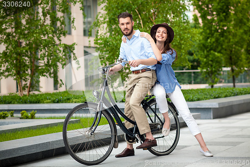 Image of Young couple sitting on a bicycle 