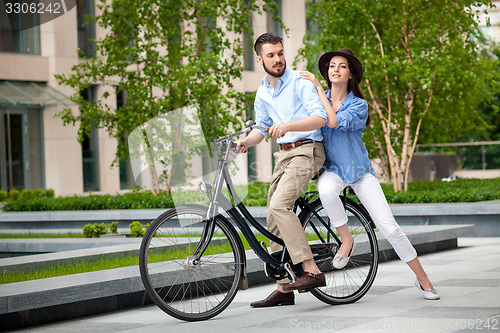 Image of Young couple sitting on a bicycle 