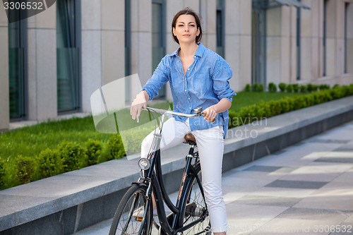 Image of Pretty girl sitting on a bicycle at street