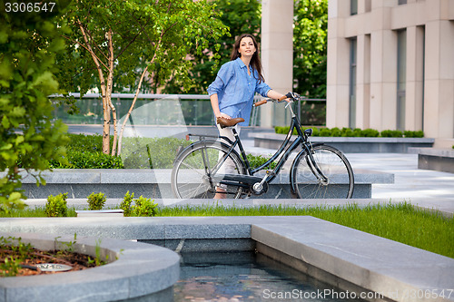 Image of beautiful girl with a bicycle on the road