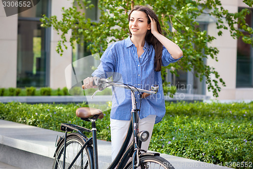 Image of beautiful girl with a bicycle on the road
