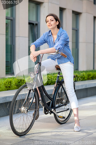 Image of Pretty girl sitting on a bicycle at street