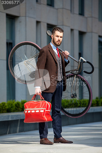 Image of Handsome businessman carrying his bicycle 