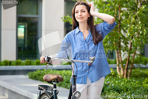 Image of beautiful girl with a bicycle on the road