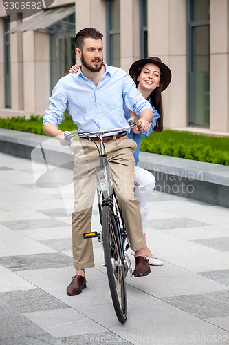 Image of Young couple sitting on a bicycle 