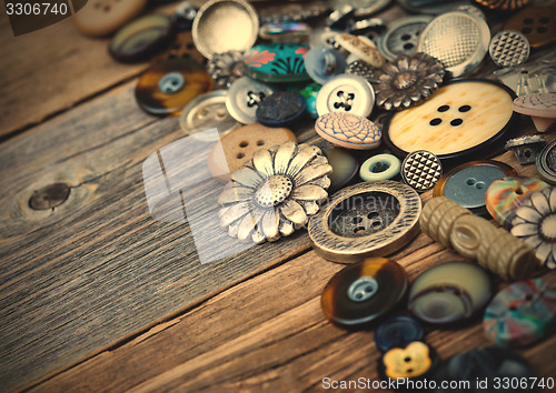 Image of old buttons in large numbers scattered on aged wooden boards