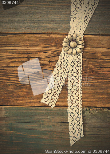 Image of silvery button flower and lace tape