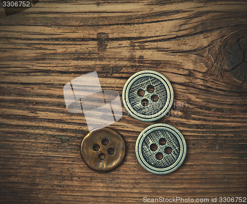 Image of set of vintage buttons on wooden boards aged antique table. inst