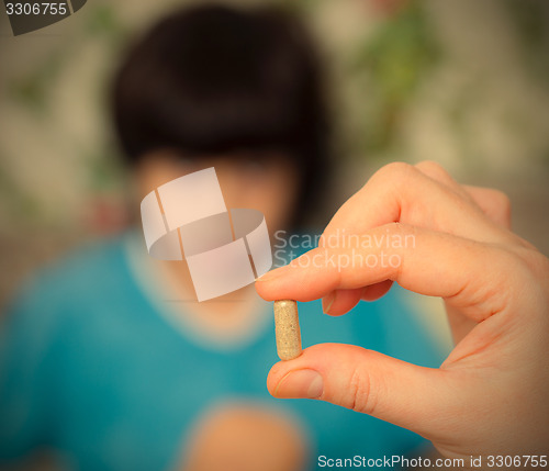 Image of hand of a  doctor with pill and child